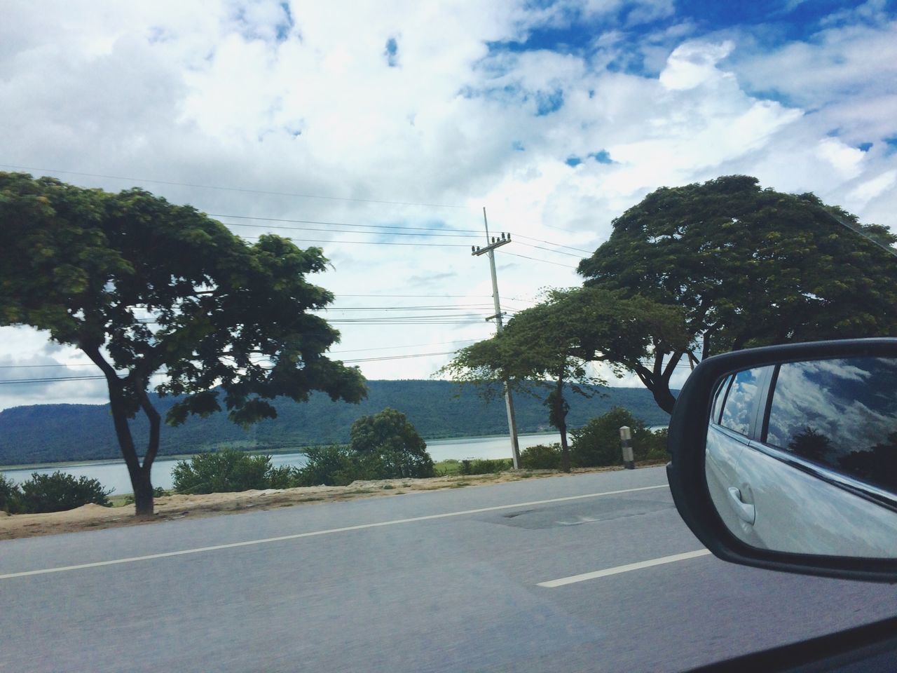 transportation, road, sky, tree, car, mode of transport, land vehicle, cloud - sky, street, road marking, the way forward, cloud, windshield, cloudy, day, travel, glass - material, outdoors, country road, vehicle interior