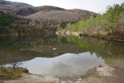 Scenic view of lake by mountain against sky