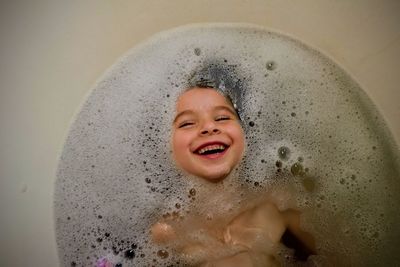 High angle view of cute smiling boy in bathtub