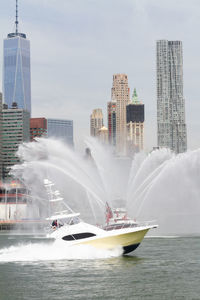 Boat spraying water in the east river with manhattan in the distance