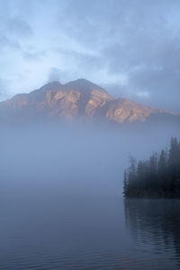 Scenic view of lake by mountains against sky