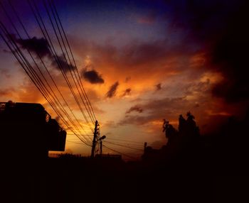 Silhouette electricity pylon against sky during sunset