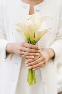 White bridal bouquet of calla lilies in the hands of the bride