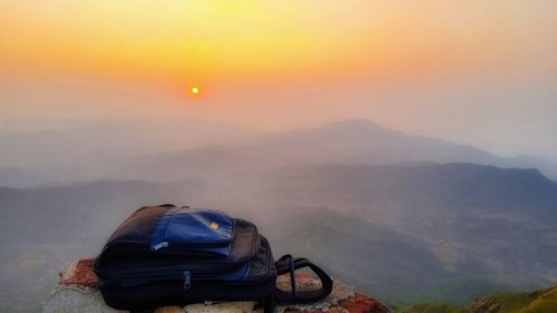 Rear view of car on mountain against sky during sunset