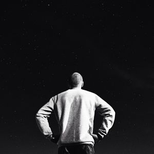 Rear view of man standing against black background