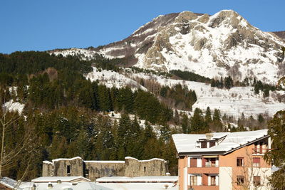 Houses on snowcapped mountains against sky