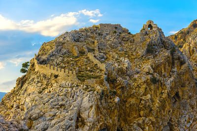 Old ruins on rocky mountains against sky