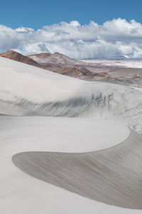 View of desert against cloudy sky