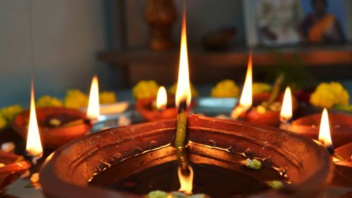 Lit tea light candles in temple against building