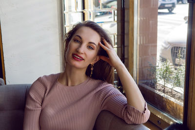 Girl in a pink jacket sitting in a restaurant with a cup of tea and a cookie heart