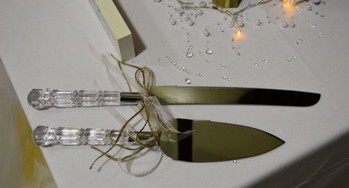 High angle view of knives by water drops on table