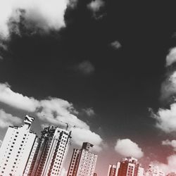 Low angle view of modern building against cloudy sky