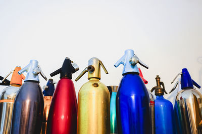 Close-up of multi colored bottles against white background