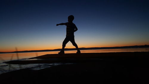 Kid punching air at dusk