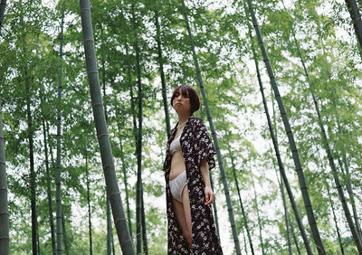 Low angle view of woman standing in forest