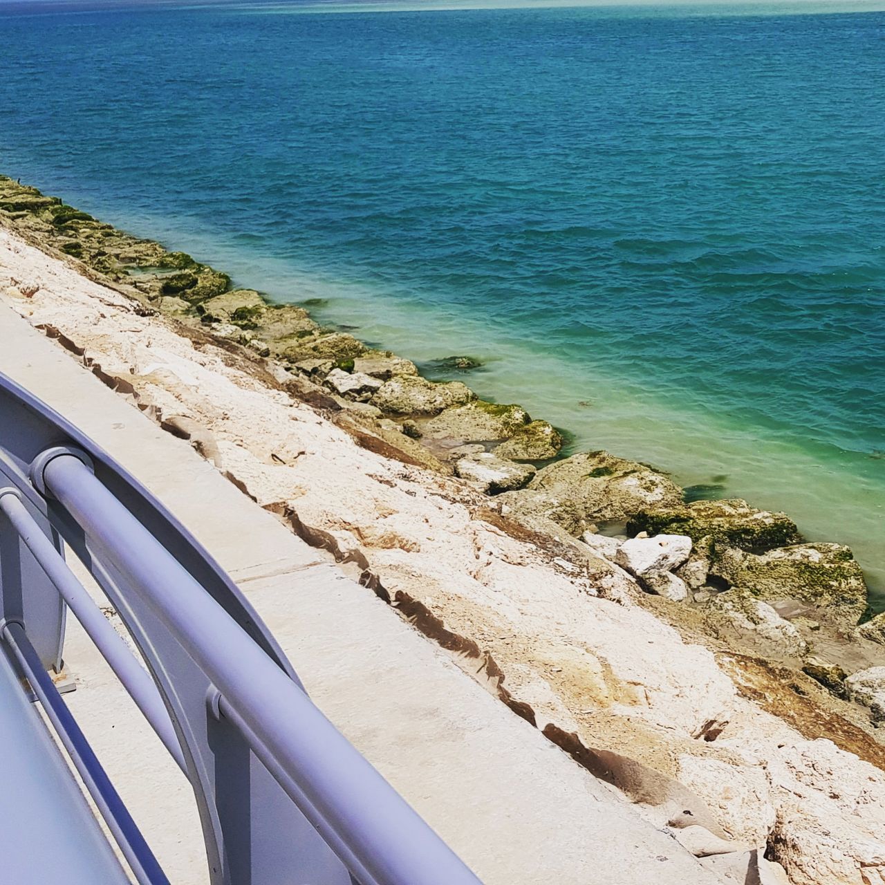 sea, water, beach, land, beauty in nature, day, scenics - nature, no people, motion, nature, high angle view, outdoors, mode of transportation, car, horizon over water, motor vehicle, blue, transportation, horizon, turquoise colored