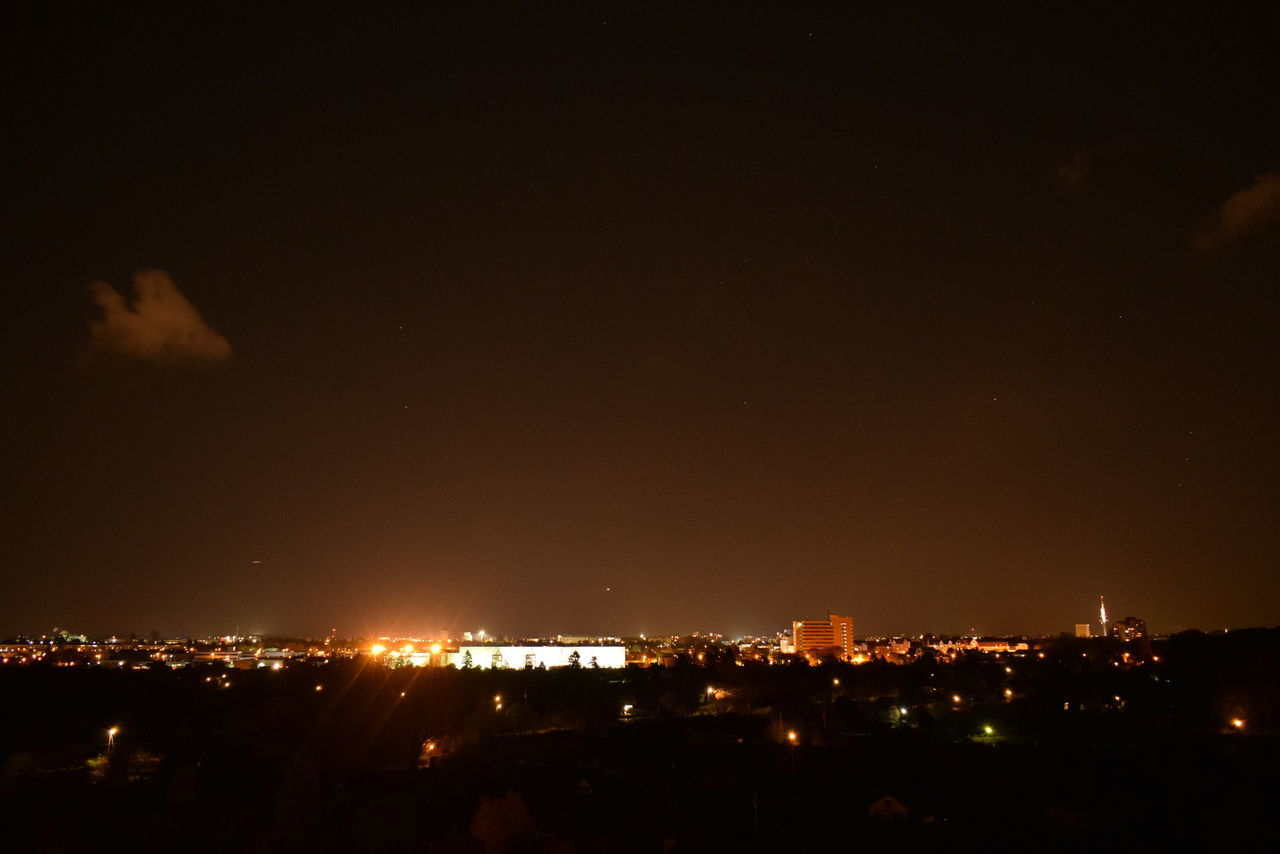 HIGH ANGLE VIEW OF ILLUMINATED BUILDINGS IN CITY AGAINST SKY