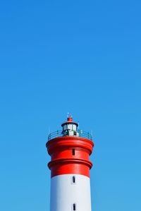 High section of lighthouse against clear blue sky