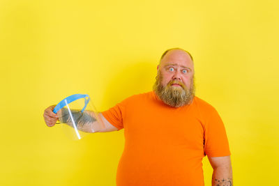 Man looking away against yellow background