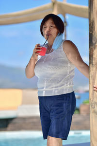 Full length of beautiful young woman drinking water