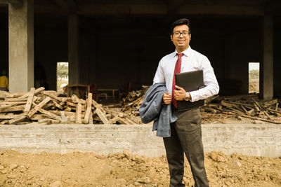 Portrait of man standing at construction site