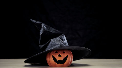 Close-up of face on table against black background