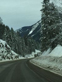 Road amidst snowcapped mountains against sky