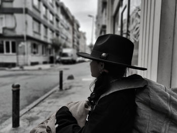 Rear view of woman wearing hat while standing in city