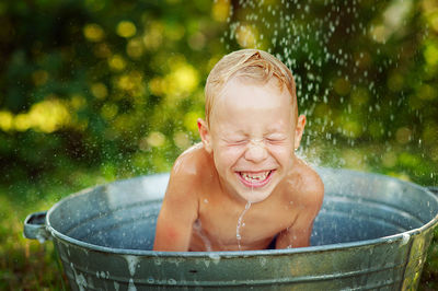 Portrait of cute baby boy in water