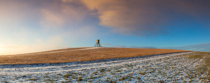 Scenic view of snowy field against sky