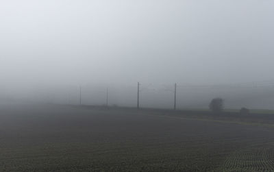 Scenic view of field against sky during foggy weather