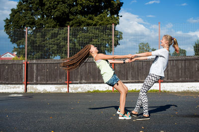 Side view of female friends playing at playground