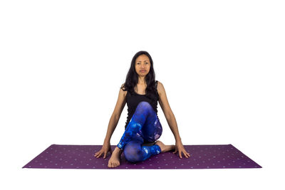 Portrait of woman sitting against white background