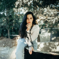 Young woman looking away while standing outdoors