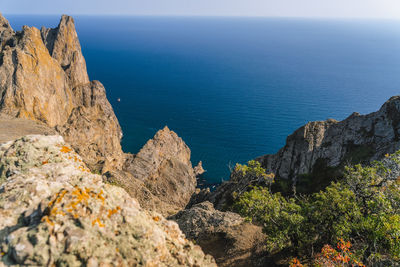 Rocks by sea against sky