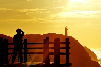 Rear view of a silhouette man overlooking silhouette mountains