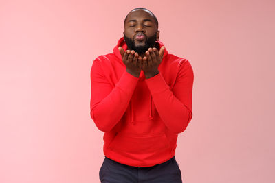 Portrait of young man against red background