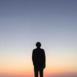 Silhouette of man standing against sky during sunset