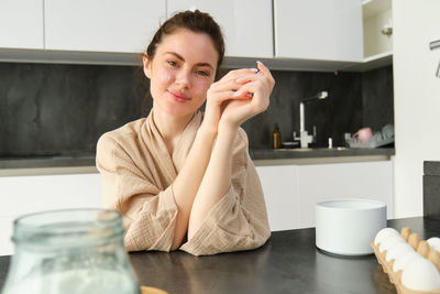 Portrait of young woman drinking coffee at home