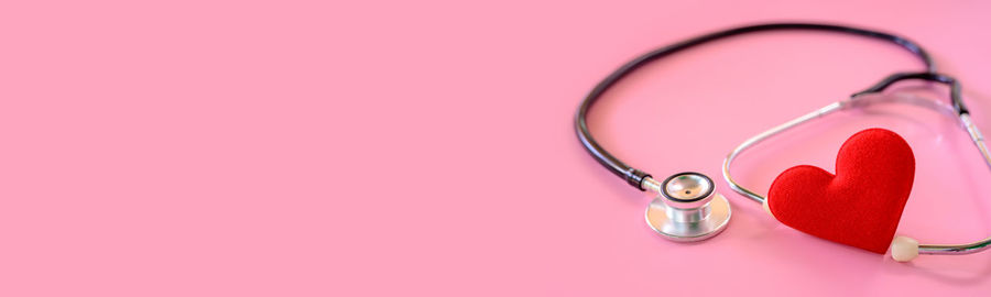 Close-up of heart shape over pink background