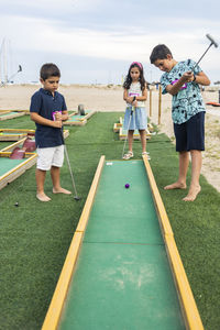 Cute kids playing golf outdoors