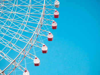 Low angle view of ferris wheel against clear blue sky