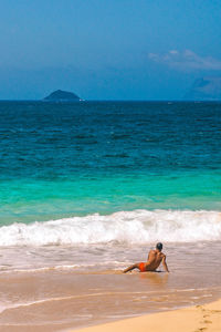 Man surfing in sea against sky