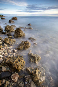 Rocks on beach against sky