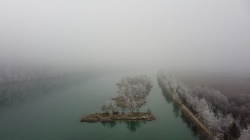 Scenic view of lake against sky during winter