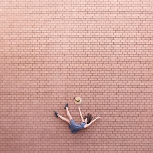 High angle view of man sitting on brick wall