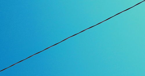 Low angle view of cables against blue sky