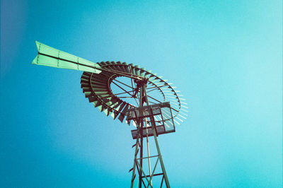 Low angle view of ferris wheel against blue sky