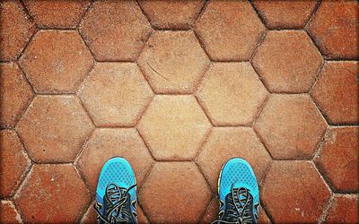 Low section of person standing on tiled floor