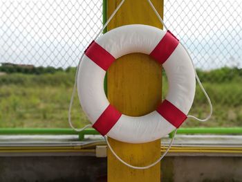 Close-up of life belt hanging on pole